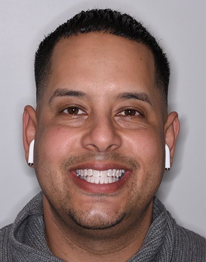Smiling man wearing wireless earbuds