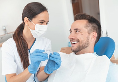 dentist and patient discussing the cost of Invisalign in Plainview