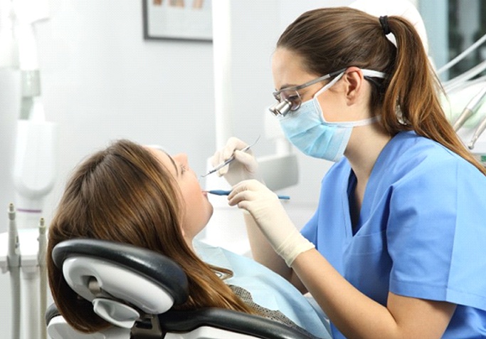 dentist examining the mouth of a patient