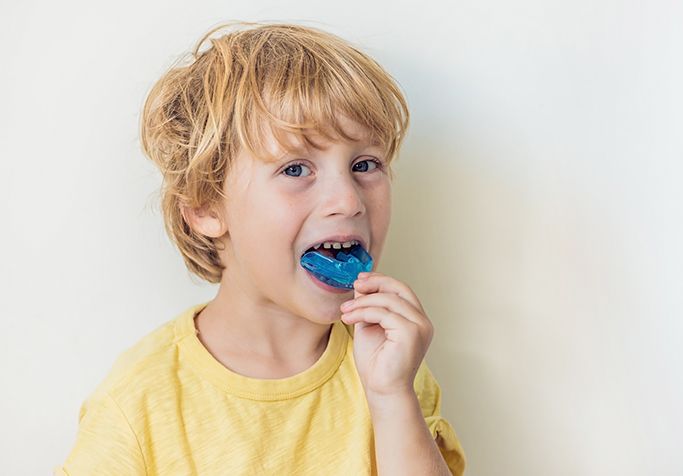 boy putting in sports mouthguard