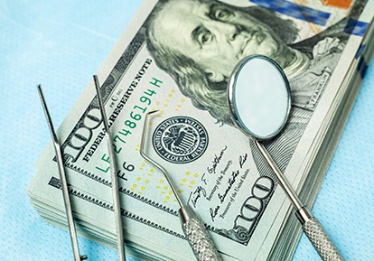 cash and dental tools on table