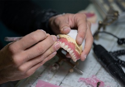 Technician putting the finishing touches on dentures in Plainview, NY