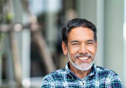 Man with beard standing outside and smiling