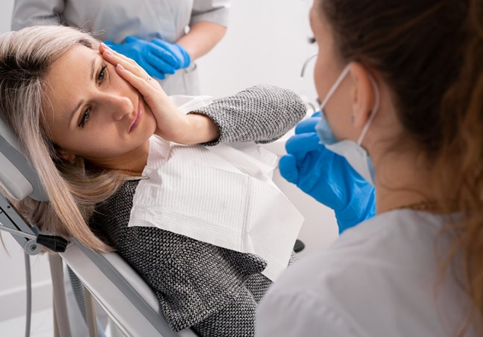 a woman experiencing a dental emergency in Plainview