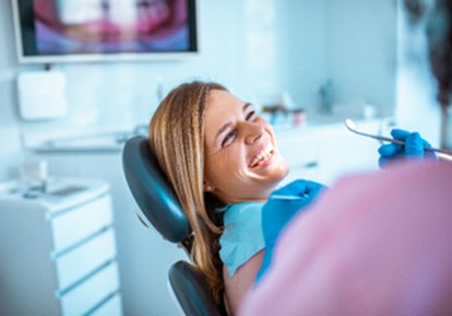 Woman smiling at dentist while sitting in treatment chair