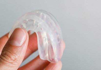 Closeup of patient holding clear mouthguards