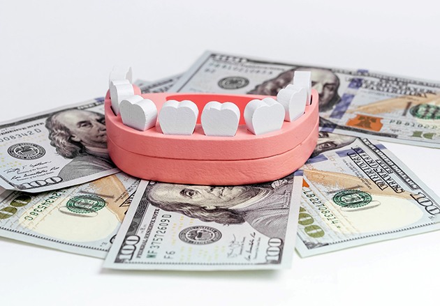 A model jaw sitting on top of dollar bills