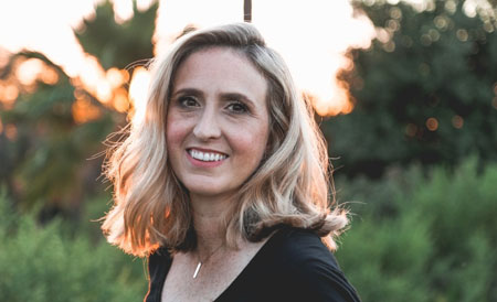 Older woman smiling outdoors at sunset