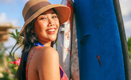 Woman in sunhat smiling outdoors