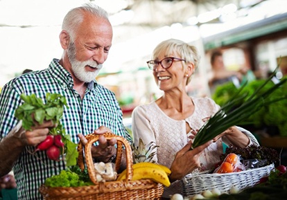senior man and woman shopping for fruits and vegetables 