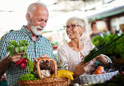 senior man and woman shopping for fruits and vegetables