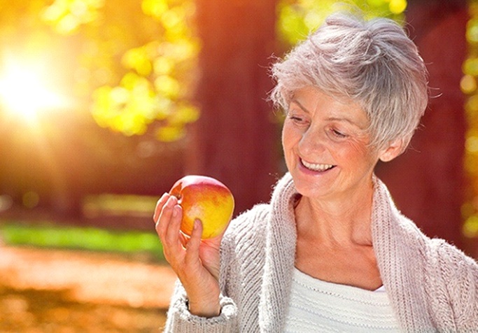 woman eating an apple outside