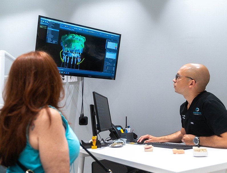 Plainview Dentist looking at image of implant dentures