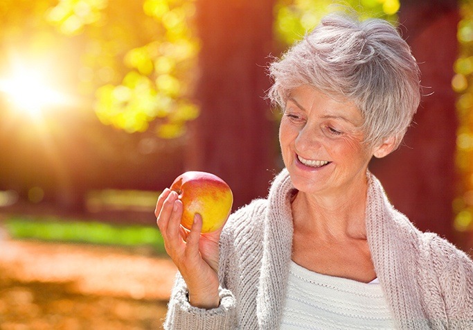 woman smiling holding apple