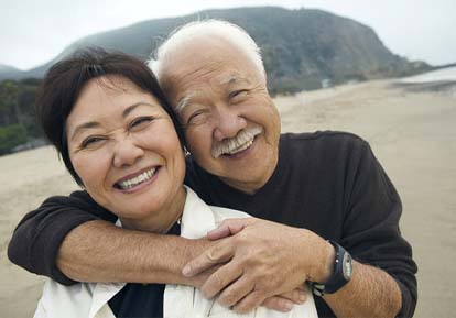 Couple smiles with dental implants in Plainview