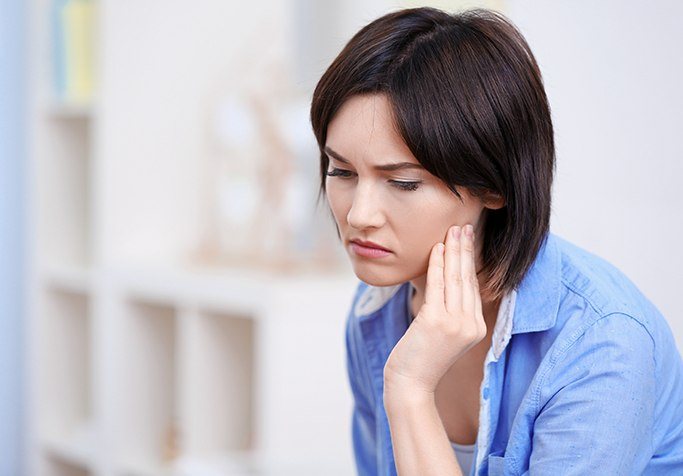 girl holding jaw in pain