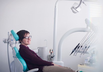 Smiling patient relaxing in dental treatment chair