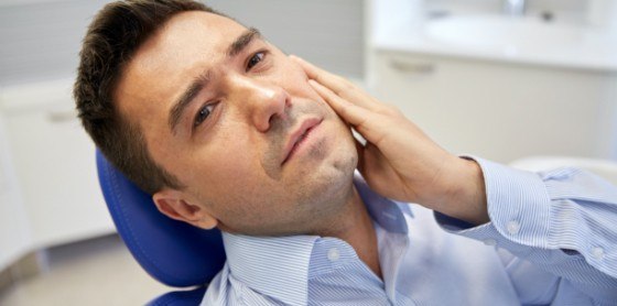 man holding jaw in pain