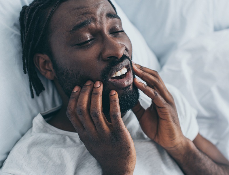 man holding jaw with both hands