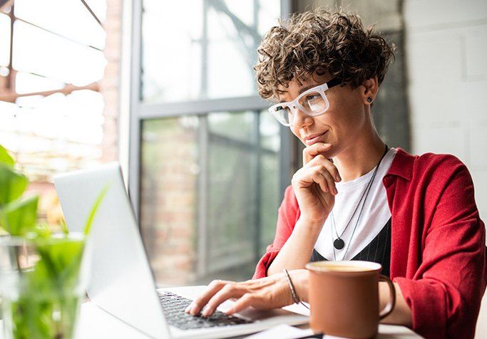 Woman sitting at desk looking at laptop