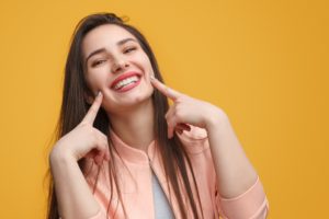 woman pointing to her smile