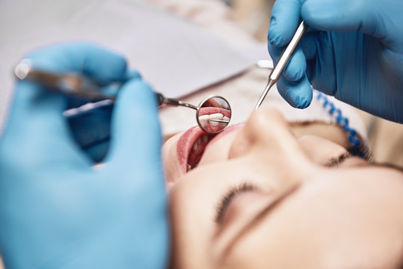 Dentist examining patient's teeth at dental checkup