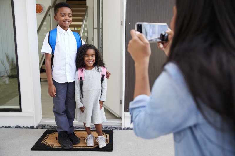 Mother taking photo of children before school