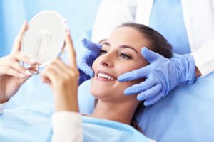 woman admiring her smile after getting cosmetic dentistry work 