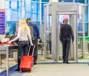 person with dental implants walking through a metal detector in an airport 