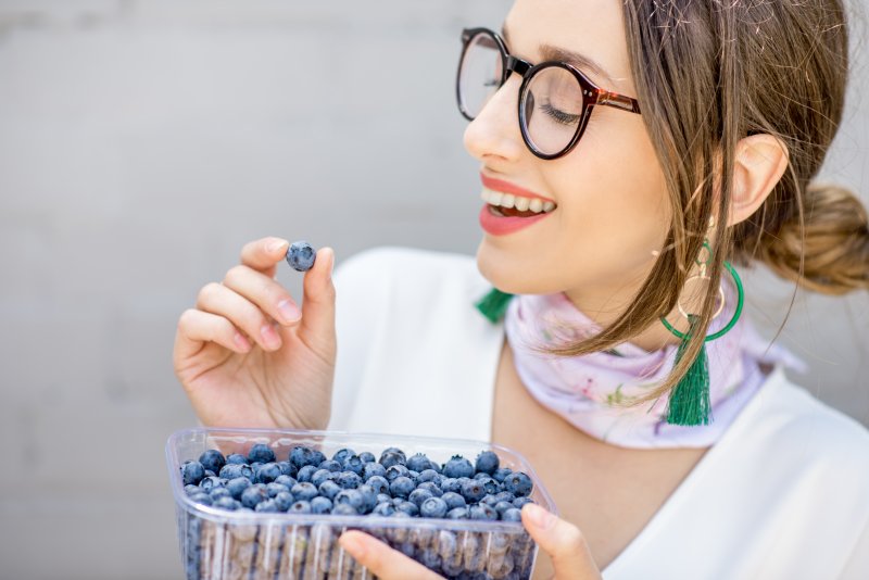 woman eating blueberries after teeth whitening in Plainview