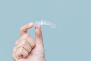 Person holding their Invisalign tray.