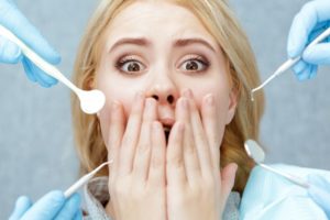 a woman covering her mouth at the dentist