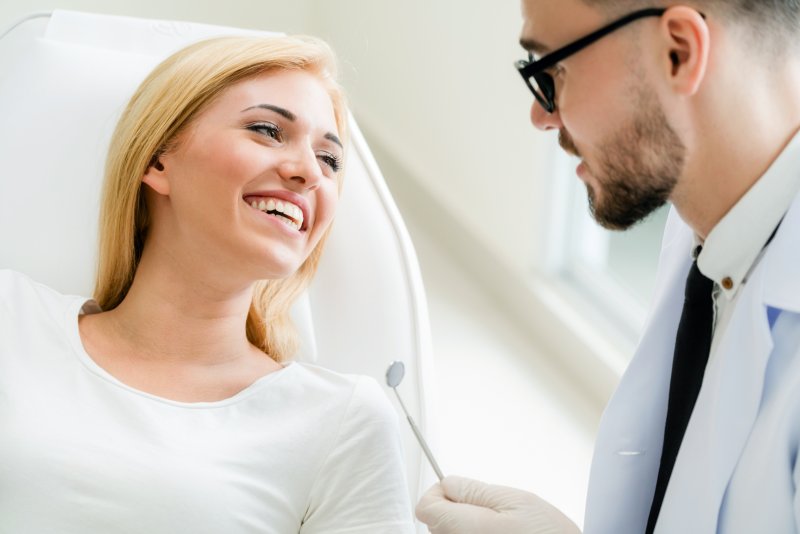 a patient talking with a cosmetic dentist in Plainview